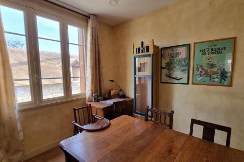 ein Esszimmer mit einem Holztisch und einem Schreibtisch in der Unterkunft Les Noyers Monestois entre Cher et Canal de Berry in Mennetou-sur-Cher