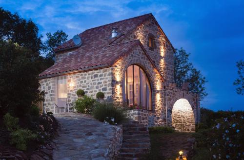 a stone house with christmas lights on it at B&B Maison des Etoiles Chambre d'hôtes Adult Only in Verrières