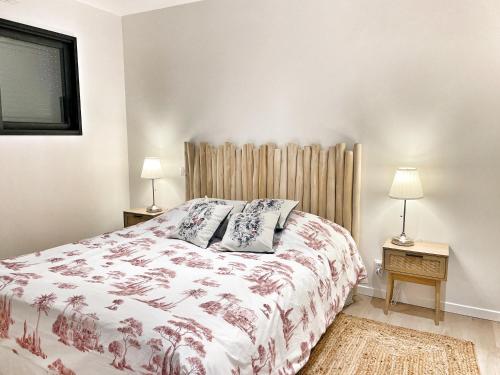 a bedroom with a large bed and two lamps at Maison neuve 4 étoiles plain-pied proche de la mer in Plurien