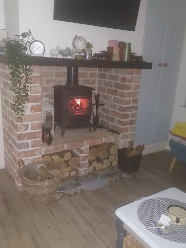 a brick fireplace with a stove in a living room at Toddys Cottage & Stables in Cavan