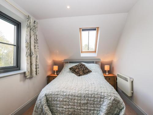 a bedroom with a bed and two windows at Nine Acres Barn in Marlborough
