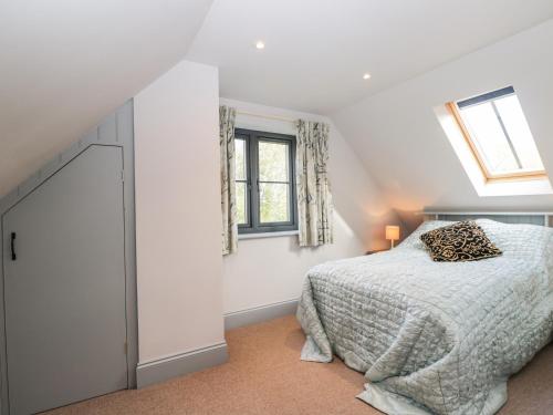 a bedroom with a bed and two windows at Nine Acres Barn in Marlborough