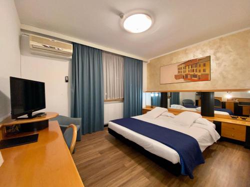 フェルトレにあるHotel Casagrandeのベッド1台、薄型テレビが備わるホテルルームです。