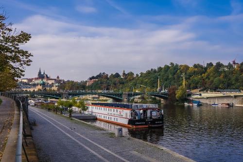 a boat traveling down a river under a bridge at River hotel KÖNIGSTEIN in Prague