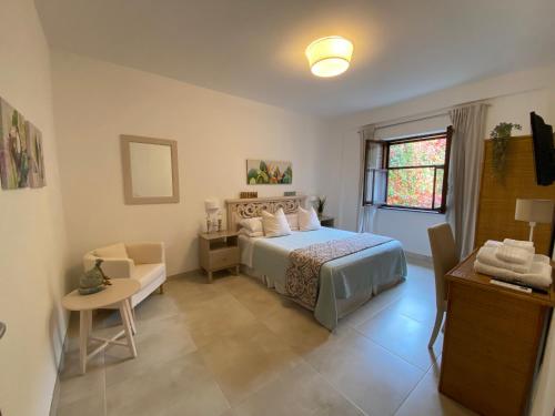 a bedroom with a bed and a table and a window at Sperlonga Shores in Sperlonga