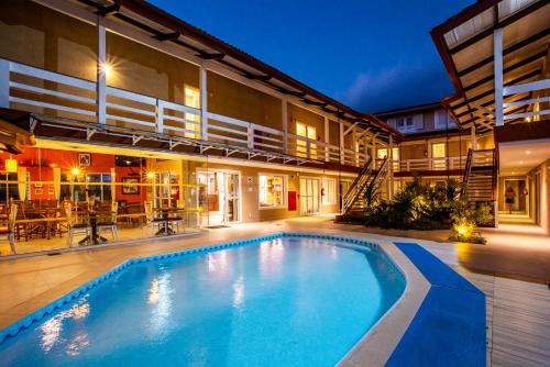 a swimming pool in the middle of a house at Ciribaí Praia Hotel in Pauba