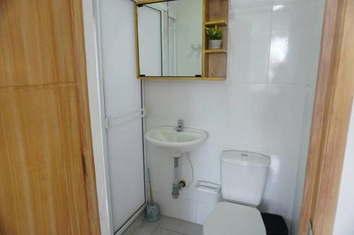 Un baño con inodoro, lavabo y espejo. en apartamento de 2 habitaciones central en Cali, en Cali
