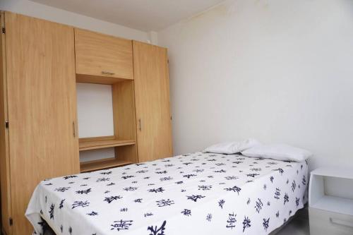 Un dormitorio con una cama y un armario de madera. en apartamento de 2 habitaciones central en Cali, en Cali