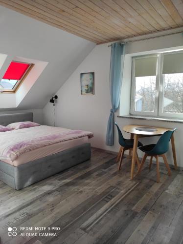 een slaapkamer met een bed en een tafel en stoelen bij Willa Relaks in Lądek-Zdrój