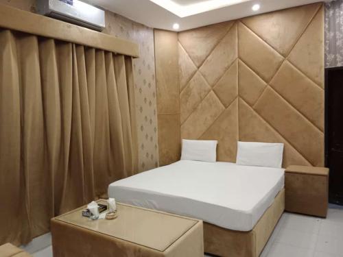 niewielka sypialnia z łóżkiem i stołem w obiekcie Hotel Sereena residence w mieście Multan