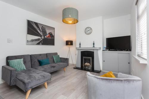 a living room with a couch and a fireplace at No 1 School House in Leyland