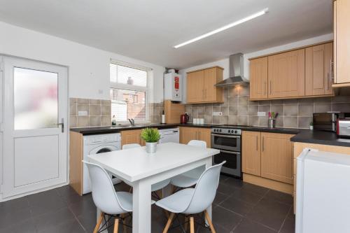 a kitchen with a white table and chairs at No 1 School House in Leyland