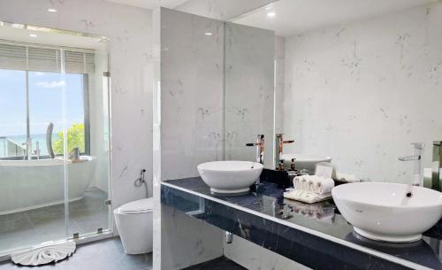 a bathroom with two sinks and a tub and a toilet at Phi Phi Holiday Resort-SHA Extra Plus in Phi Phi Islands