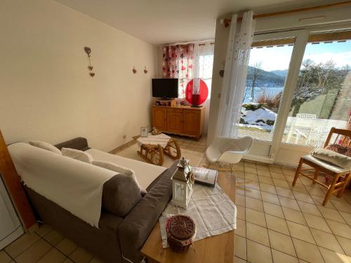 a living room with a couch and a table at Les Prairies du lac in Gérardmer