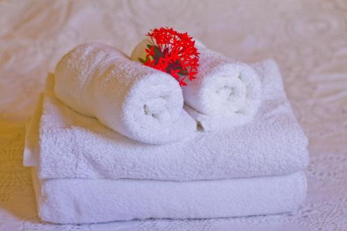 a stack of towels with a red flower on top at Village de Bragelogne in Saint-François