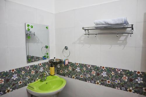 a bathroom with a green sink and a mirror at Raahi Stay, Landing site Bir - Stay & Cafe in Bīr