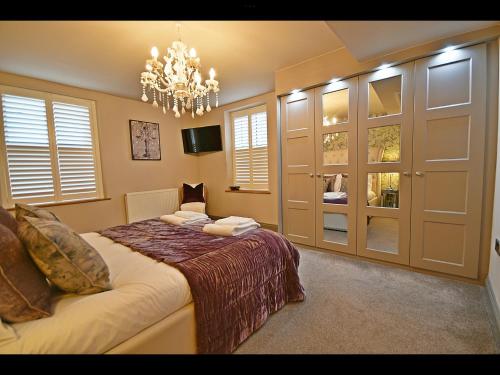 a bedroom with a bed and a chandelier at Luxury Waddington Cottage, Ribble Valley in Waddington