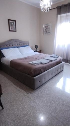 ein Schlafzimmer mit einem großen Bett in einem Zimmer in der Unterkunft Appartamento Fiore Roma Cinecittà in Rom