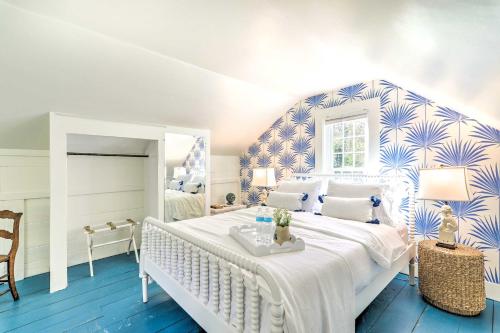 um quarto com uma cama grande e papel de parede azul e branco em The Blue Scallop Dennis Cottage - Walk to Beach! em Dennis