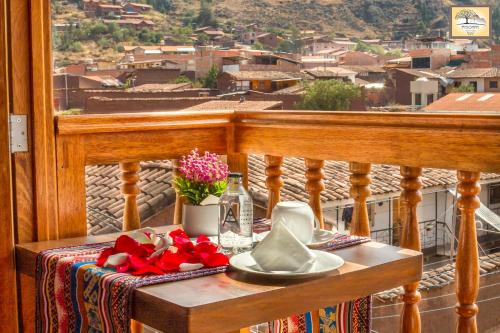 a table on a balcony with a view of a city at Pisonay Hotel in Pisac