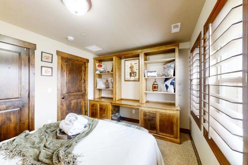 Schlafzimmer mit einem Bett und Holzschränken in der Unterkunft West Abigail Paradise in Kamas