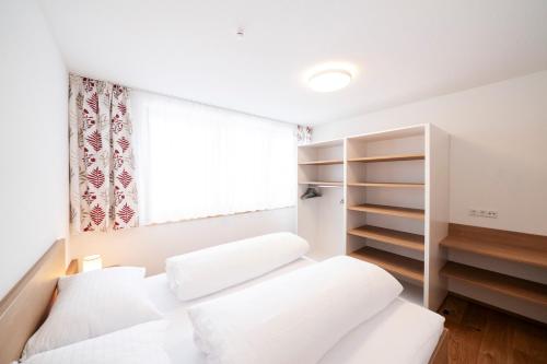 a bedroom with two beds and a window at Berg Aparts Faschina Top 7 in Fontanella