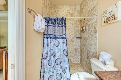 a bathroom with a shower curtain and a toilet at Anna Maria Island Surfside Bungalow in Holmes Beach