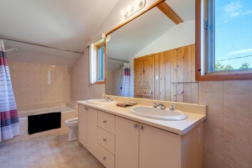 uma casa de banho com um lavatório, um WC e uma janela. em MontFJORD - Chalets, SPA et vue - ChantaFJORD #2 em Sacré-Coeur-Saguenay