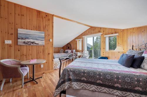 1 dormitorio con 1 cama, mesa y sillas en MontFJORD - Chalets, SPA et vue - ChantaFJORD #2, en Sacré-Coeur