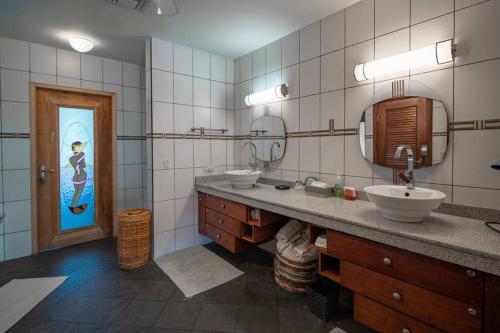 a bathroom with two sinks and a mirror at Villa Bella Mare Aruba - Steps to the beach in Palm-Eagle Beach