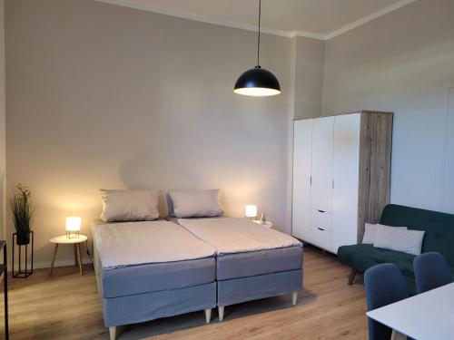 a bedroom with a bed and a couch and a cabinet at Gemütliche Ferienwohnung - Araliya 1 in Ahlbeck
