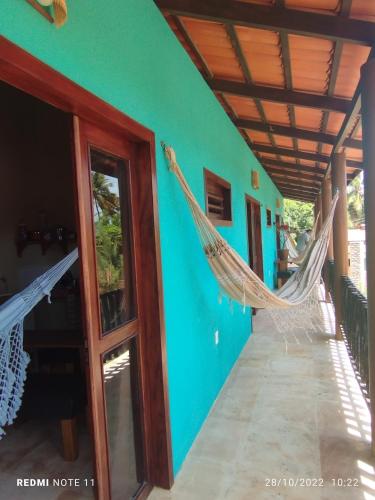 a room with two hammocks hanging from the wall at Vila Samin Moitas in Praia de Moitas