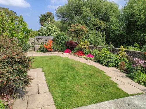 a garden with colorful flowers and a fence at Benllech Sea View bungalow, Dog Friendly sleeps 6 in Benllech