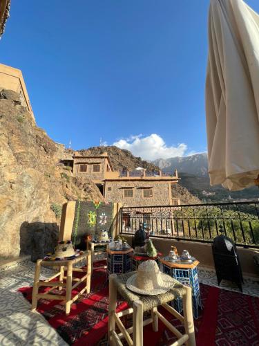 a balcony with tables and chairs on a mountain at Riad Atlas 4 seasons in Imlil