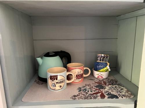 four coffee mugs sitting in a shelf in a drawer at Le logis de Lasteyrie in La Rochebeaucourt-et-Argentine