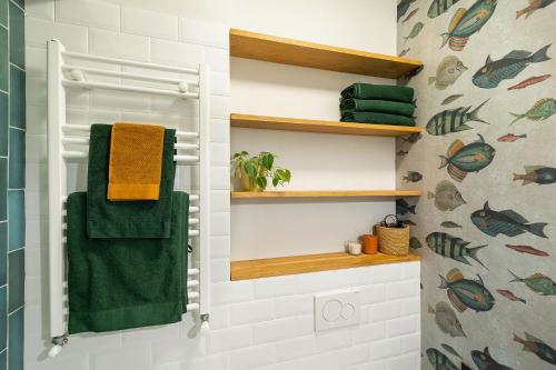 ein Bad mit einem grünen Handtuch an der Wand in der Unterkunft Bohemian Apartment in Old Town in Bukarest