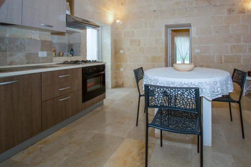 a kitchen with a table and chairs in a kitchen at Masseria La Scalella - Cisterna x 2 in Manduria