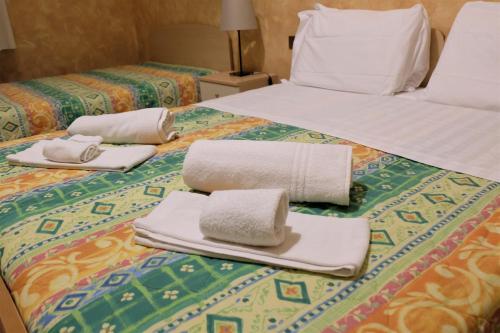 two beds with towels sitting on top of them at Hostel il Tetto in Melfi