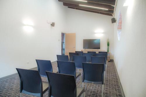 a conference room with blue chairs and a screen at Holiday Inn Tlaxcala by IHG in Tlaxcala de Xicohténcatl