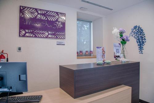 an office with a desk with a computer and flowers at Holiday Inn Tlaxcala by IHG in Tlaxcala de Xicohténcatl