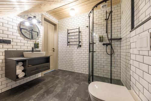 a bathroom with a shower and a toilet and a sink at Želvė Village & SPA 