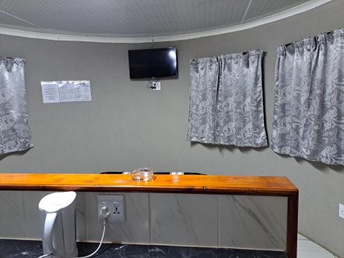 a room with a table and a television on the wall at Horizon View Chalets in Graskop