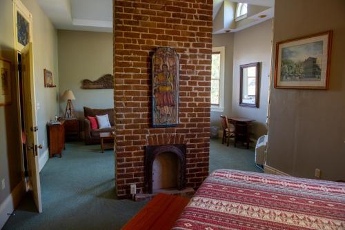 uma sala com uma lareira de tijolos num quarto em The Lookout Inn em Nova Orleães