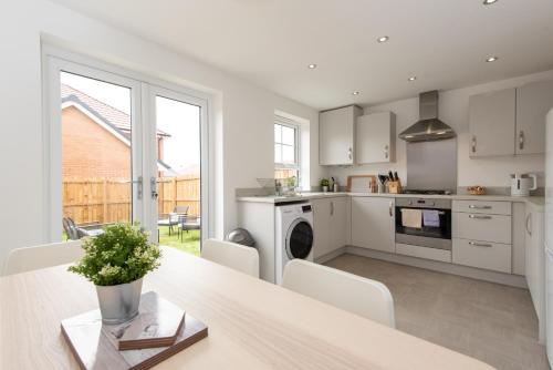 a kitchen with white cabinets and a table with chairs at Bell Road in Durham