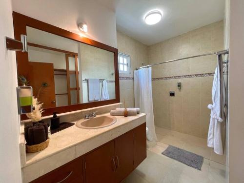 a bathroom with a sink and a shower and a mirror at Casa Mar y Amor in Cancún