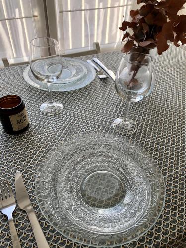 une table avec une plaque de verre et deux verres sur celle-ci dans l'établissement Charmant T2, hyper-centre, à 50m de la plage !, à Le Touquet-Paris-Plage