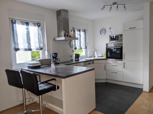 a kitchen with white cabinets and a black counter top at Ferienhaus Lindelburg in Schwarzenbruck