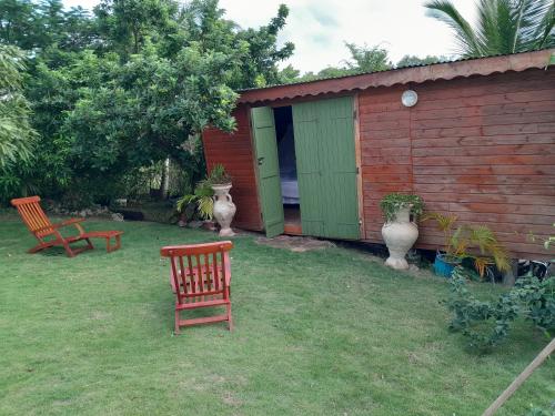 un patio con 2 sillas y un cobertizo en ankaché, en Grand-Bourg