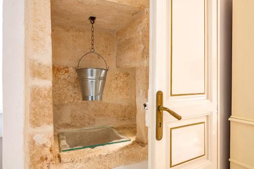 a bathroom with a sink with a bucket at Palazzo Giannotte Suite & Spa in Ostuni