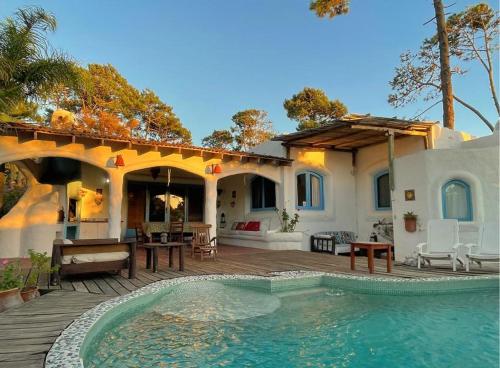 uma casa com piscina em frente a uma casa em El Delfin em Punta del Este
